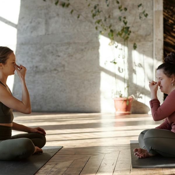 Peaceful woman meditating in sunlit room